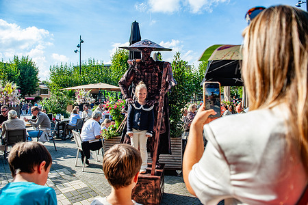 A girl takes a photo with one of the living statues. Adults and children performed as Living Statues throughout the city center, showcasing a unique urban art form that continues to amaze and entertain people of all ages. This event is organized by the "BELEEF WIJCHEN" Foundation a group of enthusiastic volunteers dedicated to creating a vibrant and lively Wijchen Center.