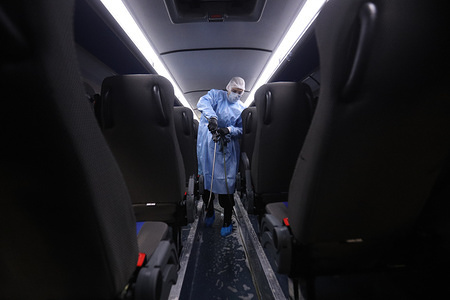 A worker in protective clothing disinfects a bus as a precaution against the spread of Coronavirus in Saint-Petersburg.