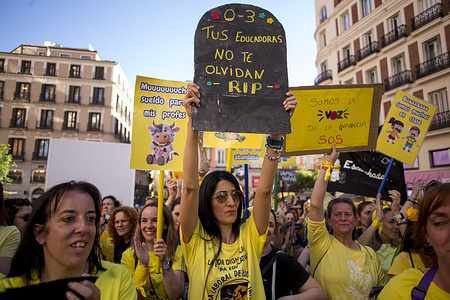 Early childhood educators (ages 0-3) hold placards during a demonstration in Madrid's Plaza Callao under the slogan "Funeral for the Nurseries," demanding better wages and an end to job insecurity.