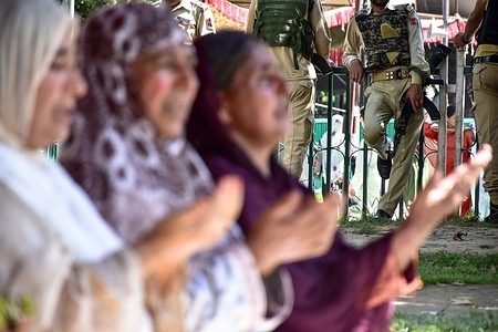 A paramilitary trooper stands guard as Kashmiri Muslim devotees pray on the occasion of Eid-e-Milad, the birth anniversary of the Prophet Muhammad (PBUH) at the Hazratbal Shrine.