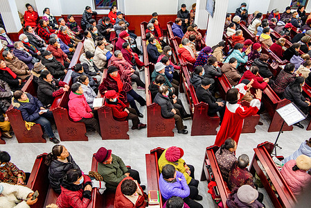 A crowd of attendees fills the pews, participating in Christmas Eve activities at the gospel church.