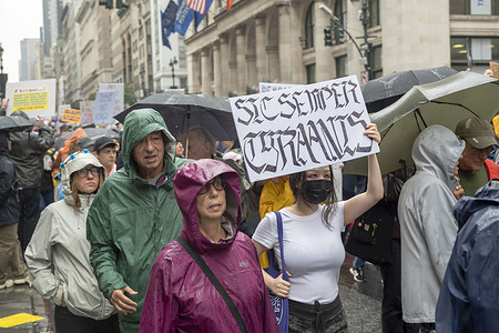 People holds signs and flags as thousands of people march in the "No Kings" protest along Fifth Avenue on June 14, 2025 in New York City. Marches and protests as part of a "national day of peaceful protest" against the Trump administration are happening across the United States today in opposition to his presidency and his policies. The national protest comes as President Donald Trump's military parade celebrating the 250th anniversary of the U.S. Army is taking place in Washington, DC. Today's parade coincides with President Trump's birthday.
