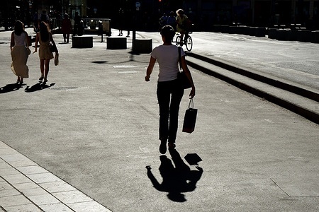 A woman with a bag in her hand enjoys the summer sales in stores in Lyon.