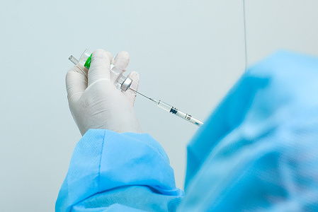 A health worker prepares a dose of the AstraZeneca vaccine to be applied on a colleague.Health workers vaccinate first line workers with doses of the AstraZeneca COVID-19 vaccine.