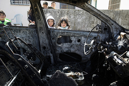 Palestinian children check their burnt car after Israeli settlers set fire to four Palestinian cars and vandalized their property and destroyed their homes in the village of Jalud, south of Nablus in the occupied West Bank. A number of Israeli settler attacks have taken place in Palestinian villages near the outposts.