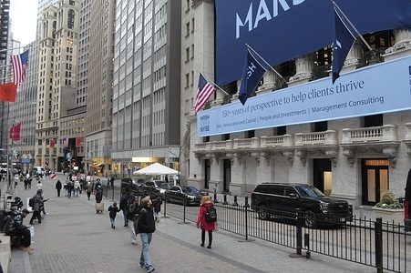 People walk past the New York Stock Exchange in the Financial District in Manhattan, New York City.