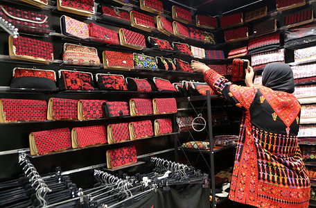 Palestinian Kifah Dweikat displays her silk-embroidered handbags in her shop in the village of Askar, east of Nablus in the West Bank. Palestinian heritage is a mosaic of historical landmarks, time-honored traditions, and a cultural legacy spanning thousands of years. Palestinian culture and heritage form an integral part of the Palestinian people's identity, reflecting their resilience, creativity, and deep connection to their land. These products are marketed in global and Arab markets.
