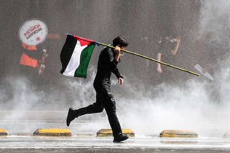 A protester runs with a Palestinian flag while being sprayed by a water cannon during the demonstration march for the resistance of Mapuche and all Indigenous peoples. A demonstration march for Mapuche resistance and all Indigenous people, took place in Santiago de Chile, bringing together dozens of people. At the same time, clashes with the police occurred, with tear gas, pepper spray and water cannons being used.