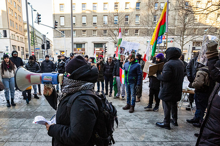 A protester addresses the assembled crowd through a megaphone during the demonstration. On the afternoon of the 18th of January, human rights protesters gathered at the EU Commission in Warsaw on behalf of the Kurdish community in response to the ongoing acts of violence against civilians in the Sheikh Maqsud and Al-Ashrafiya districts of Aleppo. These districts have historically been inhabited by the Kurdish community and have once again become targets of collective punishment against civilians, including shelling and blockades.