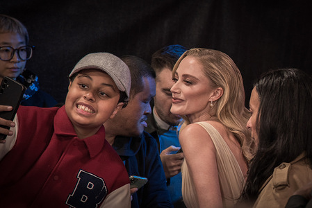 A fan poses with Maika Monroe at the Closing Night Gala Screening of "100 Nights of Hero" during The 69th BFI London Film Festival at The Royal Festival Hall.