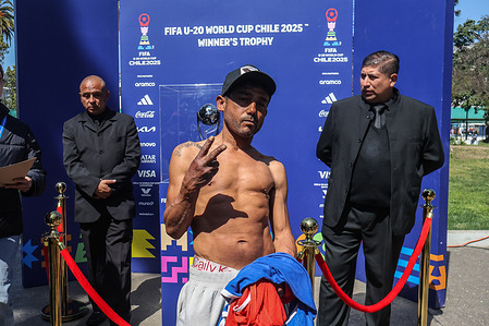 A man stands next to the trophy for the U-20 World Cup. The exhibition of the U-20 World Cup trophy.
