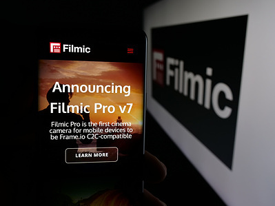 In this photo illustration, a smartphone with the web page of video camera app Filmic Pro seen on screen in front of logo.