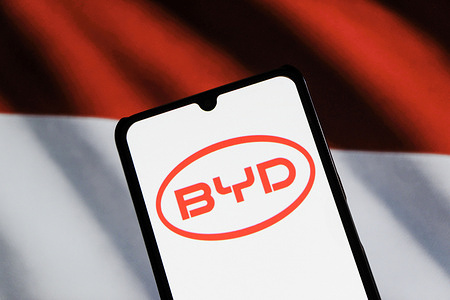 In thsi photo illustration, the BYD Automobile logo displayed on a smartphone with Indonesia flag in the background.