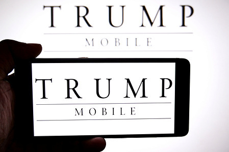In this photo illustration, a Trump Mobile logo is seen displayed on a smartphone and in the background.