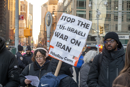 Demonstrators hold placards and flags as they rally during a protest organized by the Socialist party and other Anti-American groups against the military action in Iran at Columbus Circle on March 2, 2026 in New York City.