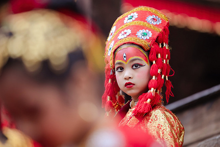 A young girl dressed as the Living Goddess Kumari takes part in the Kumari Puja festival at Hanuman Dhoka, Kathmandu Durbar Square. The annual festival, named after Indra, the god of rain and heaven, is celebrated by worshipping, rejoicing, singing, dancing, and feasting in Kathmandu Valley to mark the end of the monsoon season. Indra, the living goddess Kumari and other deities are worshipped during the festival.
