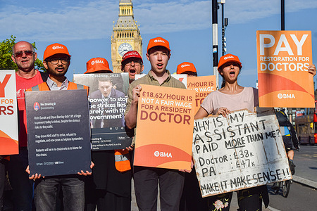 Resident doctors previously known as junior doctors stand with placards in support of fair pay at the British Medical Association (BMA) picket outside St Thomas' Hospital as they begin their strike over pay.