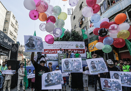 Participants holding photos of prisoners seen releasing balloons into the air, during the rally.Palestinians take part in a rally marking the 10th anniversary of the prisoners’ swap deal between Hamas and Israel. It’s been a decade since the last major swap deal between Israel and Hamas, in which Israel released over 1,000 prisoners in exchange for soldier Gilad Shalit, who spent five years in captivity.