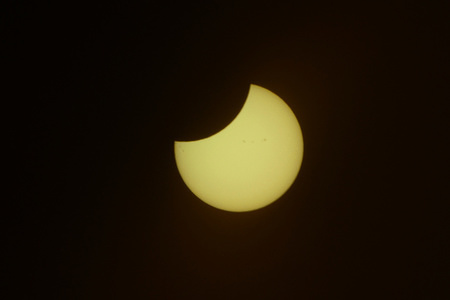 The Solar Eclipse: Part of the sun is being covered by the moon creating a partial eclipse.