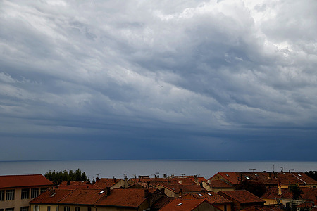 Stormy sky above the sea and rooftops of Marseille.