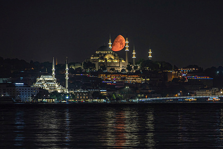 A half moon sets behind the Suleymaniye Mosque in Istanbul.