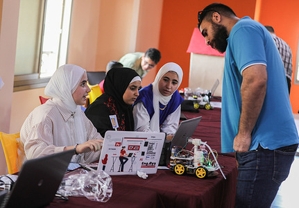 Palestinian students participate in a technology exhibition entitled "Science and Innovation" in the fields of artificial intelligence, which was organized by the Culture and Free Thought Association (CFTA) and the United Nations Relief and Works Agency for Palestine Refugees (UNRWA) in Khan Yunis, southern Gaza Strip.