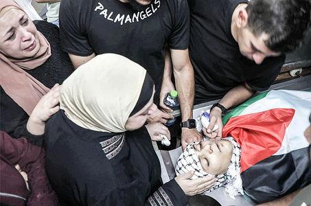 (EDITORS NOTE : Image depicts death)
Palestinians mourners seen next to the body of Mohammed al-Madani, who was killed during an Israeli army raid on the Balata refugee camp, east of Nablus in the occupied West Bank.