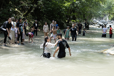 A group of people plays in the river on a hot summer day. The unprecedented heatwave in Iran has led to widespread electricity consumption, causing government offices to shut down. In many northern cities such as Chalus, people are turning to riverside water activities to escape the extreme heat.
Chalus is a city located in the northern Mazandaran Province of Iran.