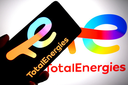 In this photo illustration, a Total Energies logo is seen displayed on a smartphone and in the background.