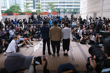 Pro-democracy activists (L-R) Joshua Wong, Ivan Lam and Agnes Chow arrive wearing face masks at the West Kowloon Magistrates' Court for charges in connection with a protest outside police headquarters in June 2019 .