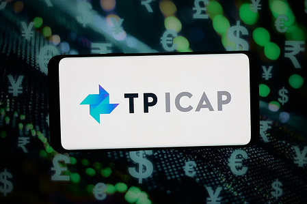 In this photo illustration, the logo of British financial company TP ICAP Group plc is displayed on a smartphone in front of abstract background on computer screen.