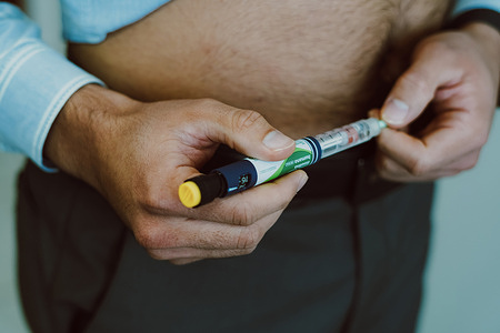 A man injects human insulin into the body for blood glucose control.