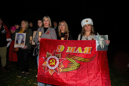 A group of people holds a banner during the 9th of May Victory Day in the Great Patriotic War by the Soviet Union at the Shrine of Remembrance. Members of Russian community got together to honor the fallen soldiers in commemoration of the Victory Day of the 1941-1945 Great Patriotic War at the Shrine of Remembrance in the late evening of the 9th of May.