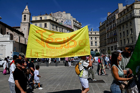 Participants hold a banner saying "Jesus is the light of the world" "Jésus m’a sauvé" in French) during the March. Christians are participating in the March for Jesus Christ in Marseille.