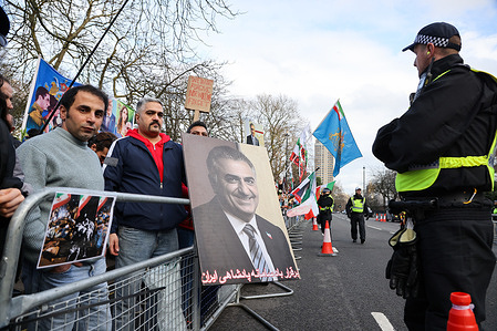 An Iranian protester holds a photograph of Reza Pahlavi during a Free Iran rally outside the Embassy of the Islamic Republic of Iran calling for political change and expressing solidarity with anti-government protests in Iran.