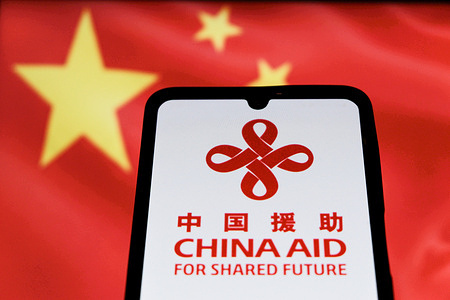 In this photo illustration, a China International Development Cooperation Agency (CIDCA) branded as China Aid logo seen displayed on a smartphone.
