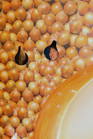A man poses for a commemorative photo in front of a giant onion monument at “Ottamage! Awaji Island” in Hyogo Prefecture, Japan. “Ottamage! Awaji Island,” a playful tourism promotion campaign highlighting the unique charm of Awaji Island with a special focus on its famous onions. “Ottamage!” is a wordplay combining tama, a Japanese term meaning “ball” and commonly used to refer to onions with ottamage, a humorous expression meaning “so surprising it makes you say ‘Wow!’” The concept expresses Awaji Island’s fun, unexpected appeal through bold, eye-catching visuals. The campaign is part of the “Awaji Island’s Surprising Charms” project organized by Uzunokuni South Awaji Co. Ltd. It features whimsical, onion-themed installations and interactive attractions located at the Uzunoka Onaruto Bridge Memorial Hall and surrounding areas. Designed to be highly photogenic, the installations encourage visitors to take playful photos against a scenic coastal backdrop creating a memorable and lighthearted way to experience Awaji Island’s local culture and specialties.