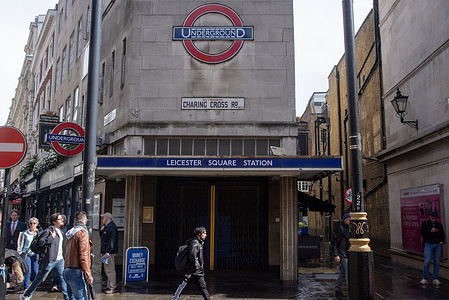 People walk in front of the closed gates of the Leicester Square Station. Members of National Union of Rail, Maritime and Transport Workers (RMT) went on strike demanding higher hourly wage, shorter shift patterns and fatigue management from the Transport for London (TfL).