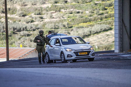 Israeli soldiers search a vehicle while securing the street near the area where three Palestinians were shot in the village of Surra, west of Nablus, in the occupied West Bank. Israeli forces fatally shot the gunmen who opened fire on troops. It was the latest bloodshed in a year-long wave of violence in the region.