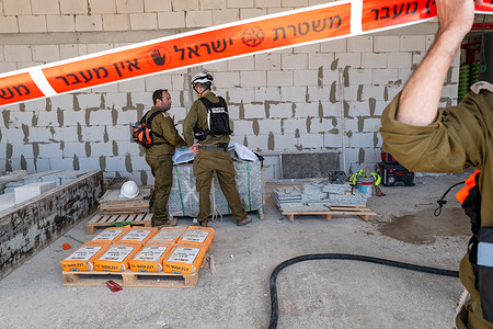 Israeli Home Front Command rescue and emergency personnel operate at the site of a missile impact. Two men were killed after a ballistic missile carrying a cluster munition warhead struck a construction site during a missile barrage launched from Iran. The attacks come amid escalating regional tensions following joint U.S.– Israeli strikes on Iranian targets in late February.