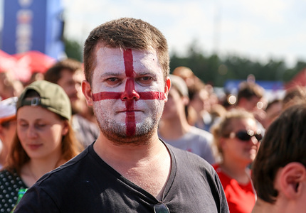 A fan of the England national team seen with his face painted in the colors of the national flag.