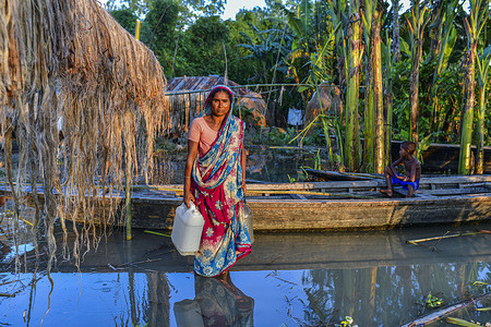 A woman walks through a flooded road at Sariakandi in Bogura.
More than four million people are being affected by the monsoon floods in Bangladesh, with a third of the country already underwater after some of the heaviest rains in a decade, officials said.