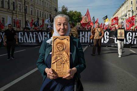 An Orthodox believer holding a wooden icon takes part in a religious procession along Nevsky Prospect in honor of the Day of the Translation of the Relics of Saint Blessed Prince Alexander Nevsky.
