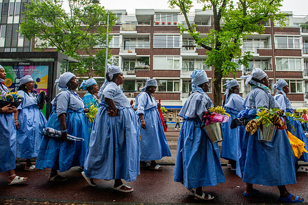 A group of Surinamese women is seen taking part in the Keti Koti parade. Keti Koti marks the date when slavery was abolished in Suriname in 1863. The event opens with a colorful parade with participants in traditional clothing called Bigi Spikri. The parade started at the city council and ended at the Slavery monument place in Oosterpark.
