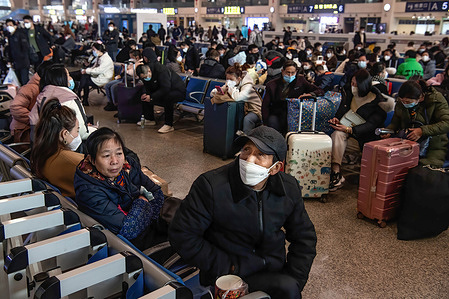 A passenger wearing face mask looks at a train timetable on a big screen while waiting at the departure area of Hankow Railway Station on the first day of China's spring festival travel rush in Wuhan. Around 6.3 million passenger trips are expected to be made across China on Saturday, the first day of this year's Spring Festival travel rush, the national railway operator China State Railway Group said. China optimized its epidemic control management recently, and epidemic measures for travel were also optimized last month. Travelers no longer need negative nucleic acid test results or health codes, are not required to undergo nucleic acid testing or health inspection upon arrival, and will not have their temperatures checked.