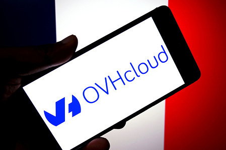 In this photo illustration, an OVHcloud logo is seen displayed on a smartphone with the flag of France in the background.