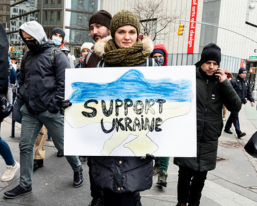 Woman holds a sign saying "Support Ukraine" at a "Stop Putin" rally organized as a response to the war in Ukraine.