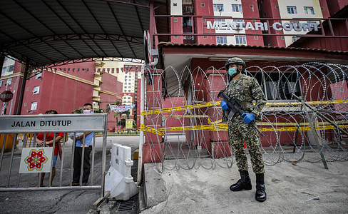An armed soldier wearing a mask and gloves stands on guard outside a residential area placed under the enhanced movement control order (EMCO) due to surge in the number of COVID-19 daily cases recorded.
Malaysia government starts to further tighten the movement control and imposes lockdown in state of Selangor and parts of Kuala Lumpur, due to the daily high number of coronavirus infections cases reported.