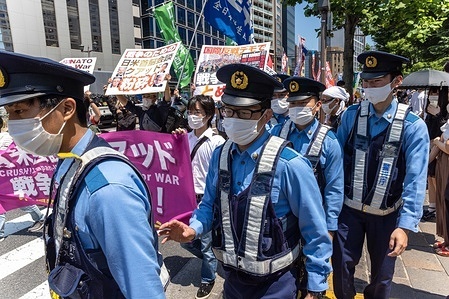Police officers ensure the safety of a small group of protesters in central Tokyo on their way to the Prime Minister's office. A small group of around 100 protesters gathered in central Tokyo to protest against the Quad Leaders' Meeting 2022 and to express their opinions about the ongoing war in Ukraine criticizing Russia, USA and NATO. They also called out Japanese Prime Minister Fumio Kishida to step down as well as the US President Joe Biden.