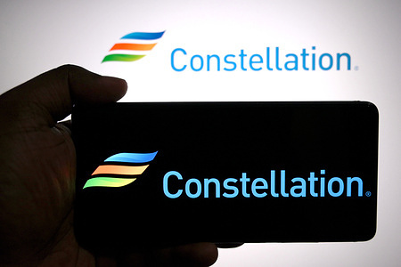 In this photo illustration, the Constellation Energy logo is seen displayed on a smartphone and in the background.